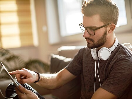 Student schaut in Tablet und sucht nach Hilfsangeboten