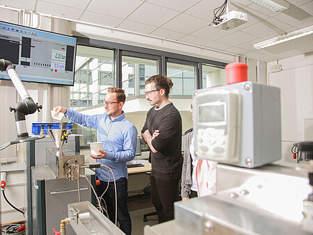 Laboringenieur Harald Wehner (links) und Studierender (rechts) am Extruder 